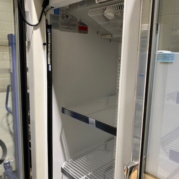 Left side door open with white wire racks inside freezer