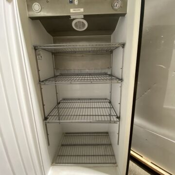 Front view inside open door freezer with 4 shelves