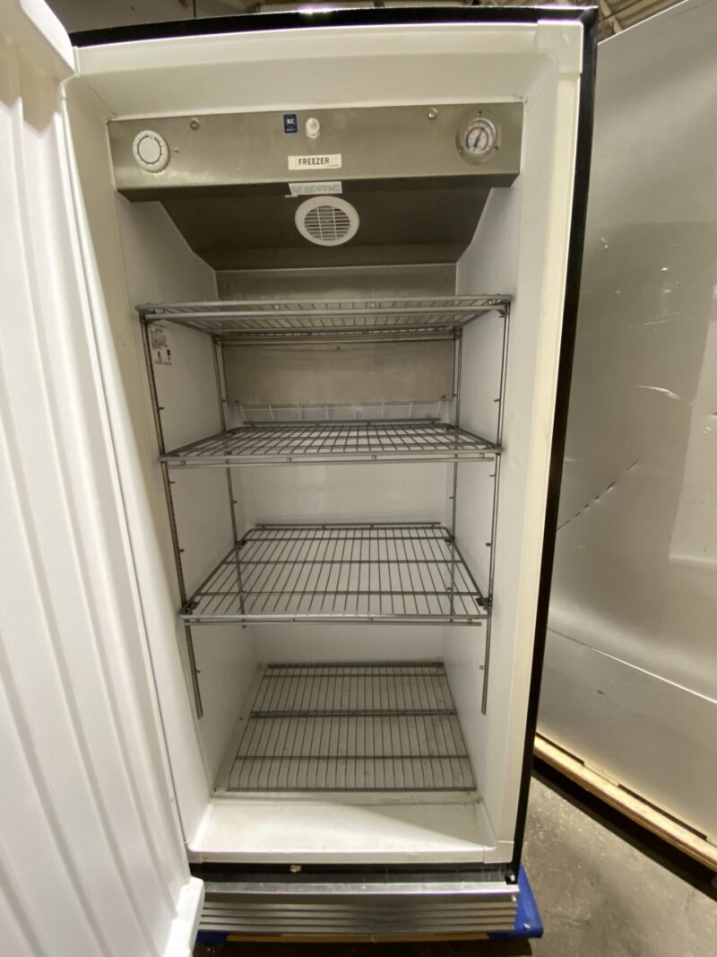 Front view inside open door freezer with 4 shelves