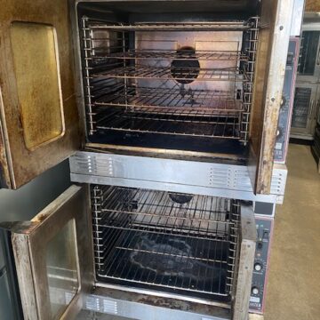 Open doors to double decker convection oven with wire racks inside