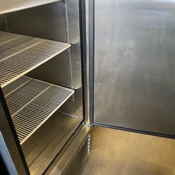 Angled left side upright stainless steel cooler single door open with 3 white wire shelves