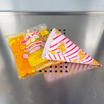 bag of popcorn kernals with popcorn holder on tray