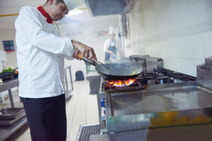 chef cooking over fire on range oven top