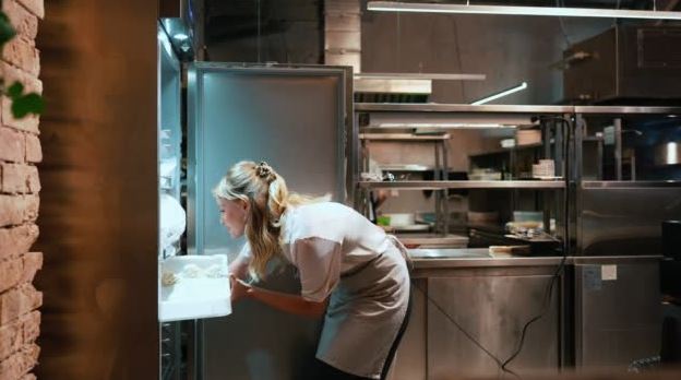 woman chef putting food away in freezer
