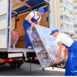 2 men moving a piece of furniture to the ground