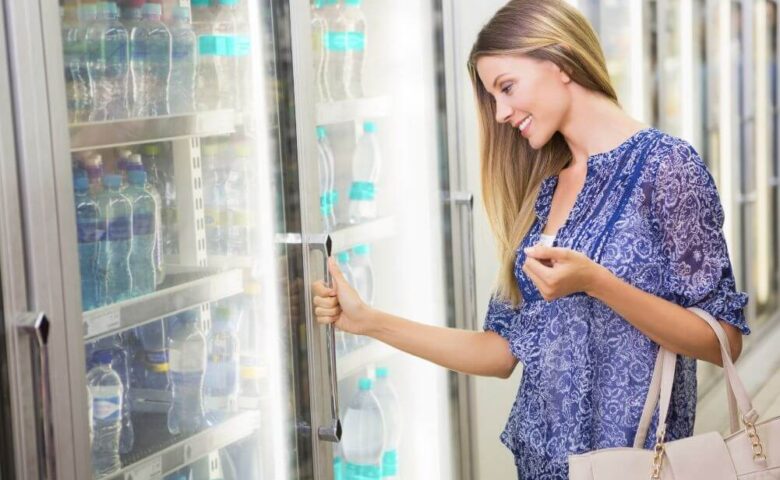woman opening glass door refrigerator