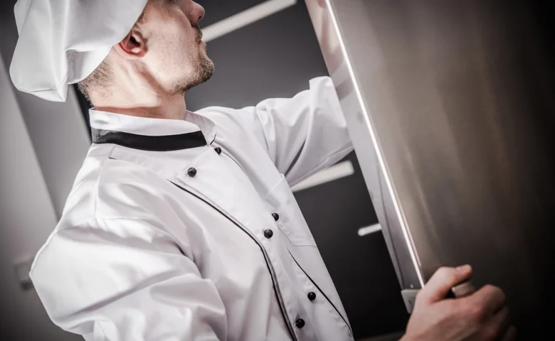 man looking into a upright freezer